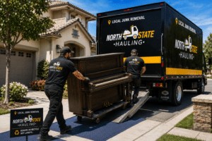 North State Hauling crew loading an upright piano into a removal truck at a Brentwood, CA home.